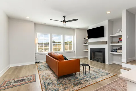 a living room with a fireplace a flat screen tv and a refrigerator