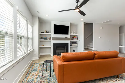 a living room with a fireplace and flat screen tv