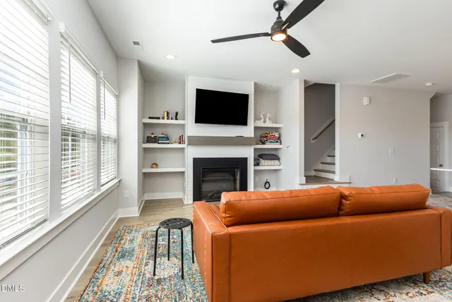 a living room with a fireplace and flat screen tv