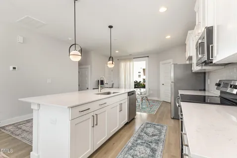 a kitchen with stainless steel appliances granite countertop a sink a stove top oven and cabinetry