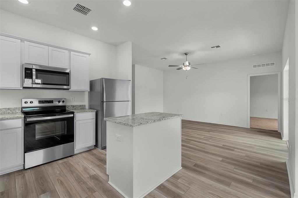 13283 Tula Loop Astatula, FL 34705 - Photo 4 of 19 a kitchen with a refrigerator and a stove top oven