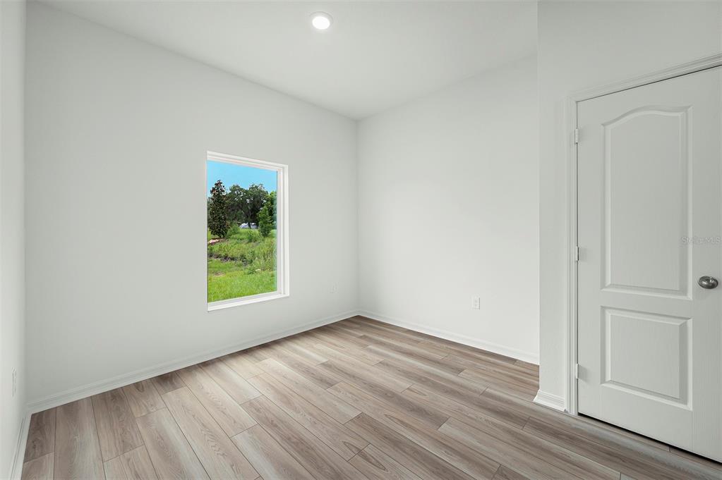 13283 Tula Loop Astatula, FL 34705 - Photo 10 of 19 an empty room with wooden floor and window