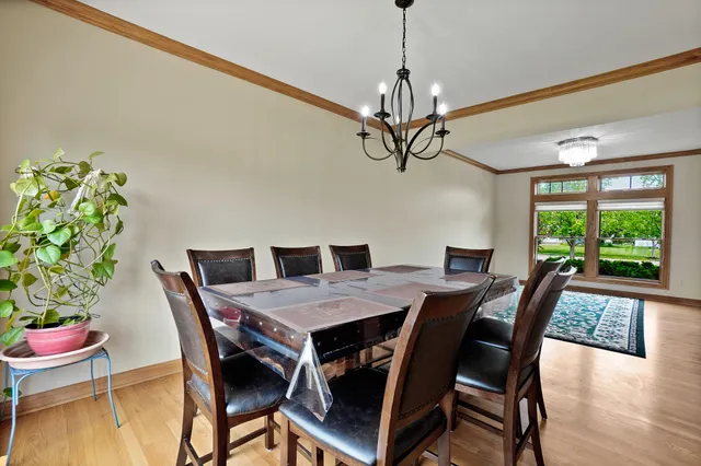 a kitchen with stainless steel appliances kitchen island granite countertop a stove a sink a refrigerator with a dining table and chairs