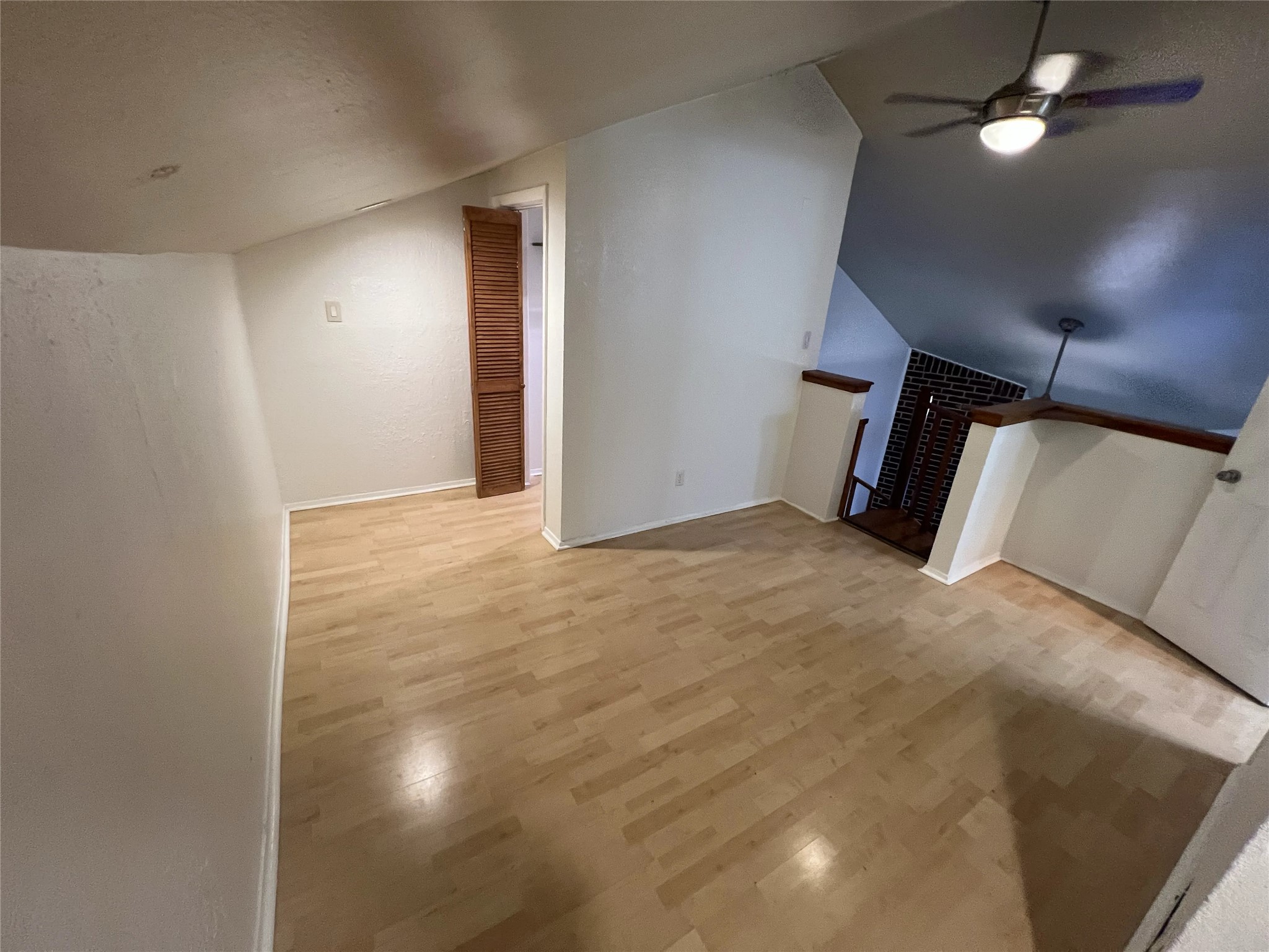 2500 Burleson Road, Unit 622 Austin, TX 78741 - Photo 12 of 17 A versatile open loft space features wood flooring and a vaulted ceiling with a fan.