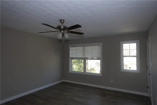 an empty room with a window and a fan