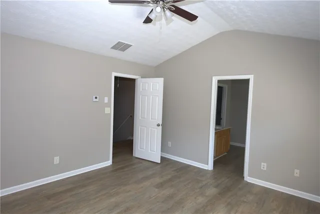 a view of an empty room with window and a ceiling fan