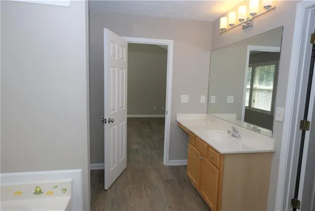 a bathroom with a double vanity sink a mirror and a bathtub