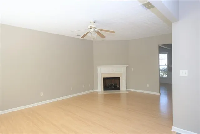an empty room with windows and fireplace