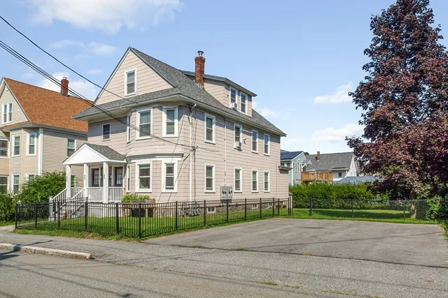 a front view of a house with a garden and plants