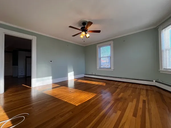 a bedroom with natural light and hardwood floor