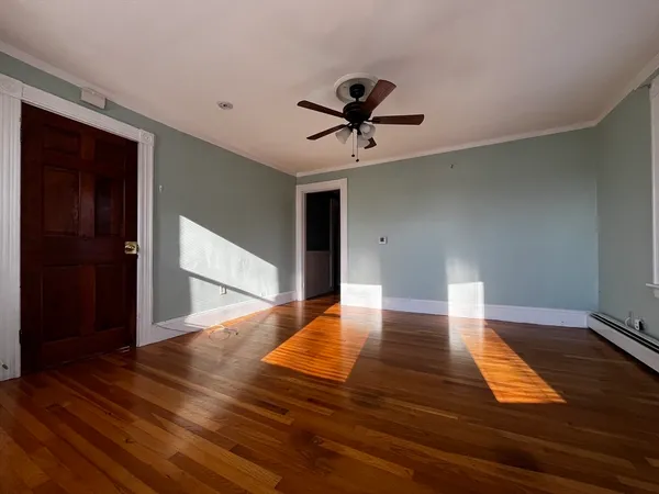 a view of empty room with wooden floor