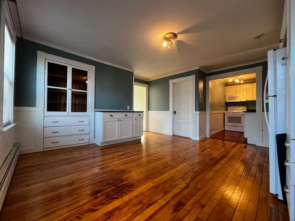 a view of empty room with wooden floor and windows