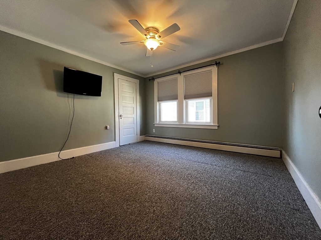 263 Middlesex Street, Unit 2 North Andover, MA 01845 - Photo 10 of 16 an empty room with windows and ceiling fan