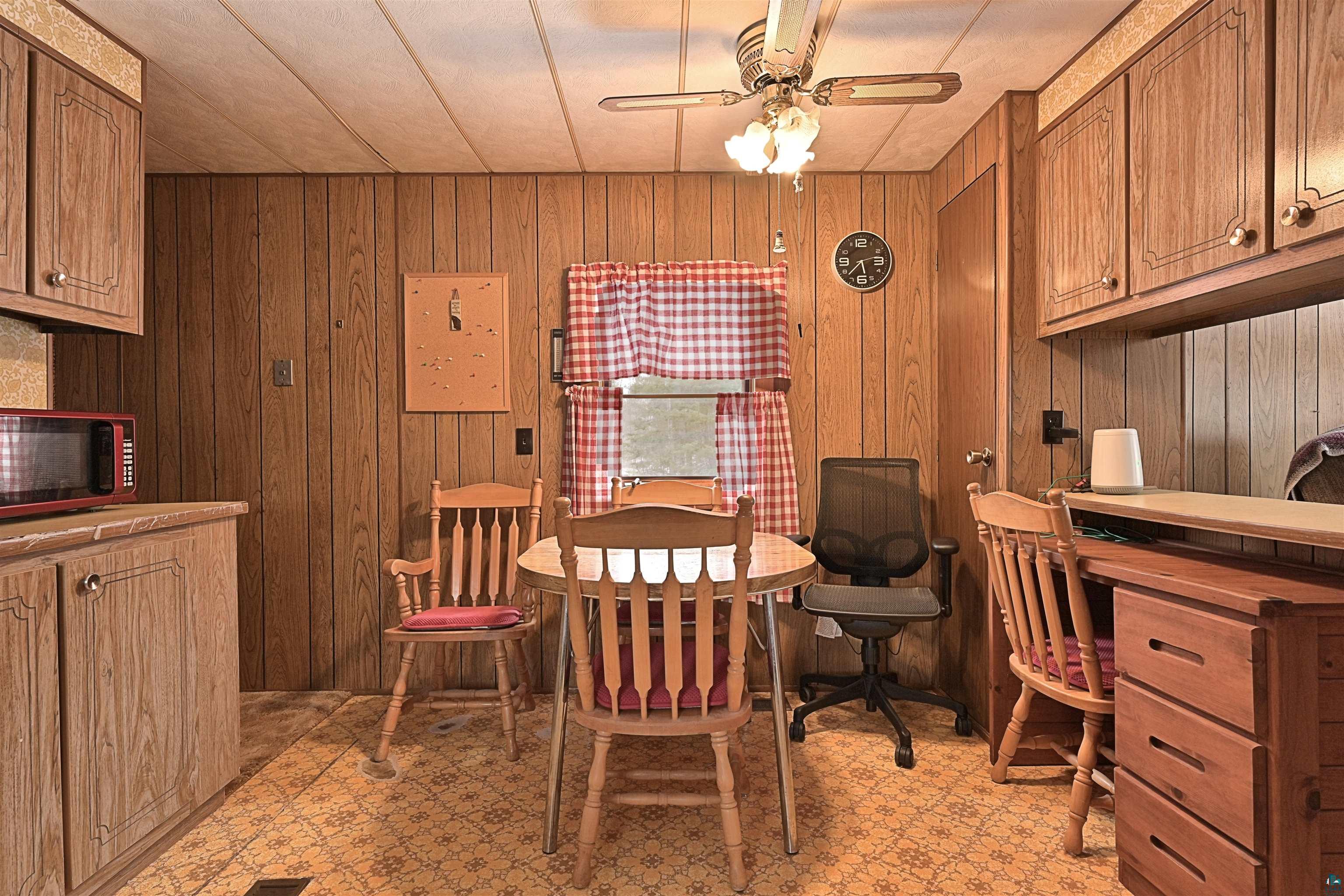 6800 Salveson Road Finland, MN 55603 - Photo 11 of 20 Dining space with light floors, a ceiling fan, and wood walls
