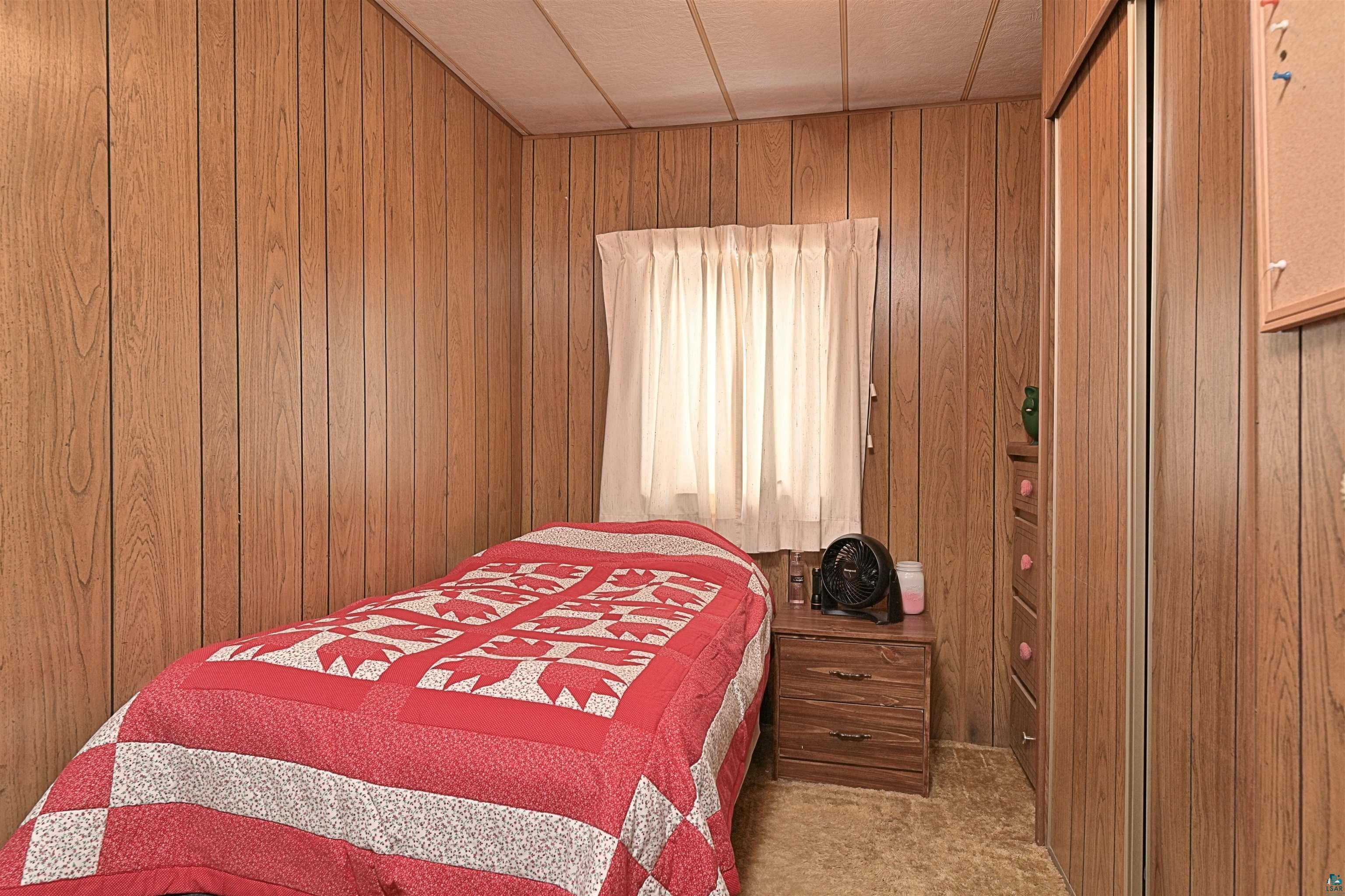 6800 Salveson Road Finland, MN 55603 - Photo 16 of 20 Bedroom with light carpet and wood walls