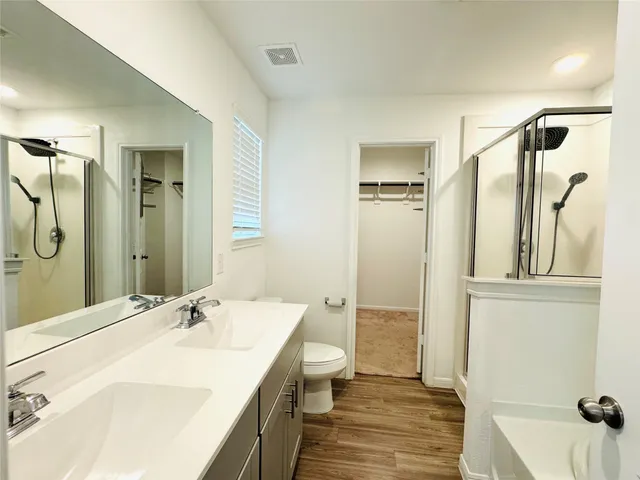 a bathroom with a sink a toilet and shower