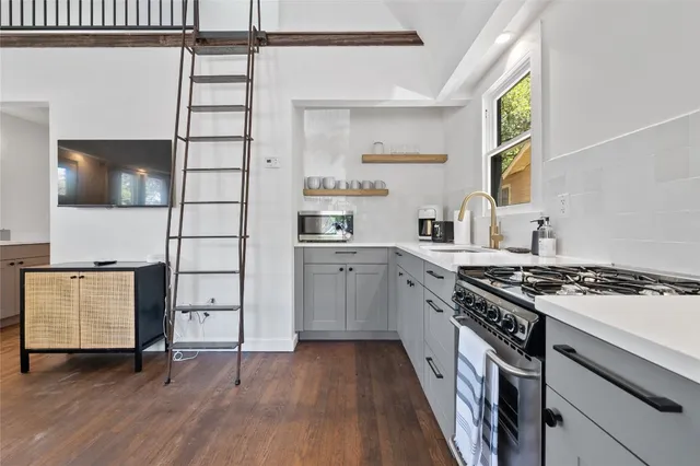 a kitchen with granite countertop a stove and a wooden floors
