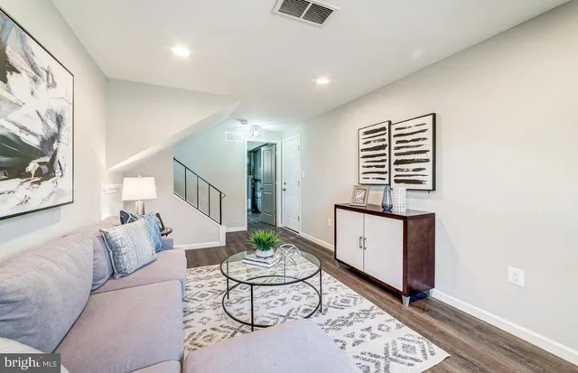 a living room with furniture a table and wooden floor
