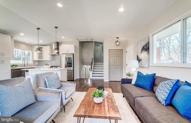 a living room with furniture kitchen and a large window