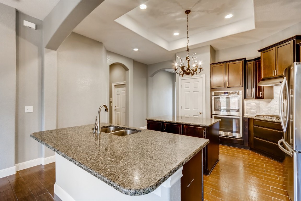 6108 Sabino Drive Spicewood, TX 78669 - Photo 4 of 22 a kitchen with stainless steel appliances granite countertop a kitchen island a stove and a sink