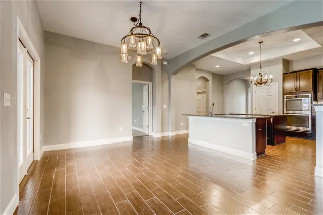 a view of a room with wooden floor and a kitchen