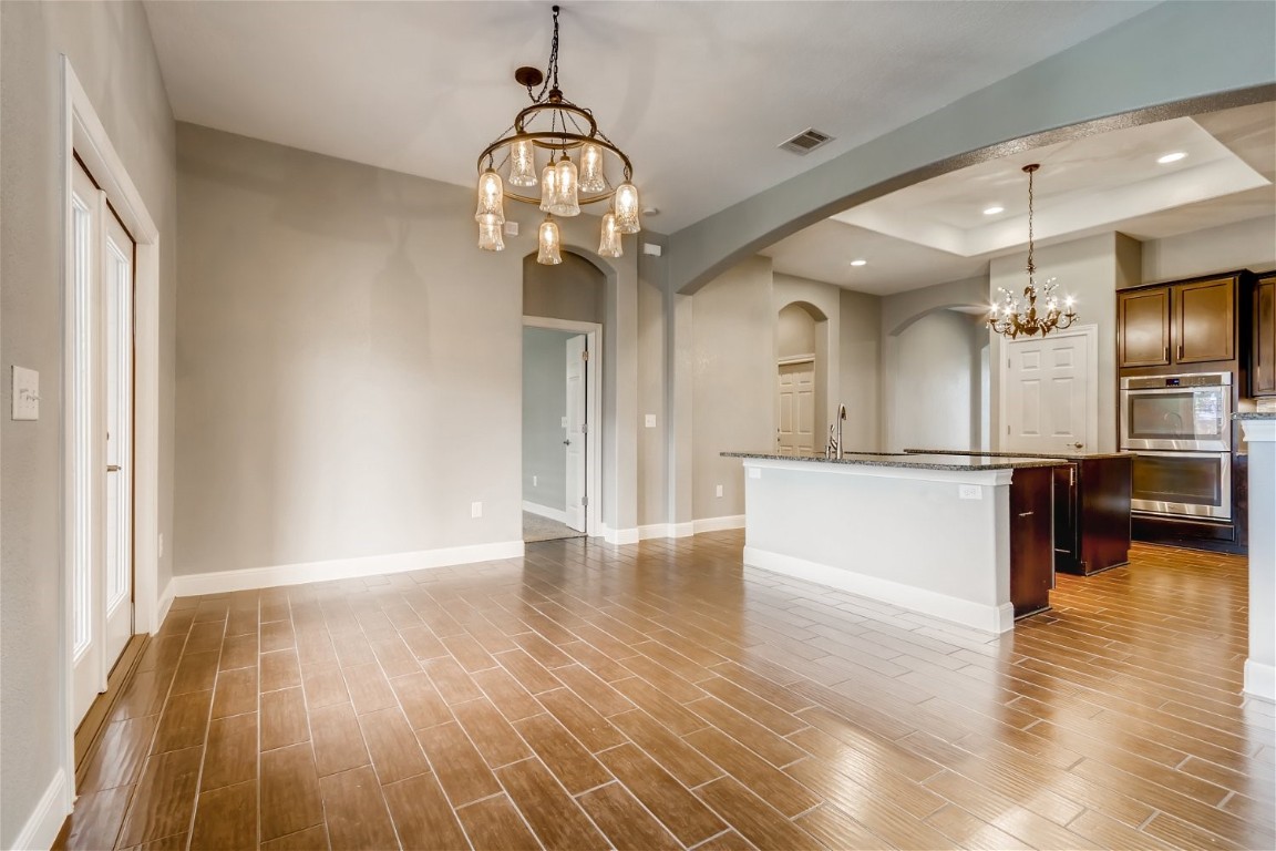 6108 Sabino Drive Spicewood, TX 78669 - Photo 6 of 22 a view of a room with wooden floor and a kitchen
