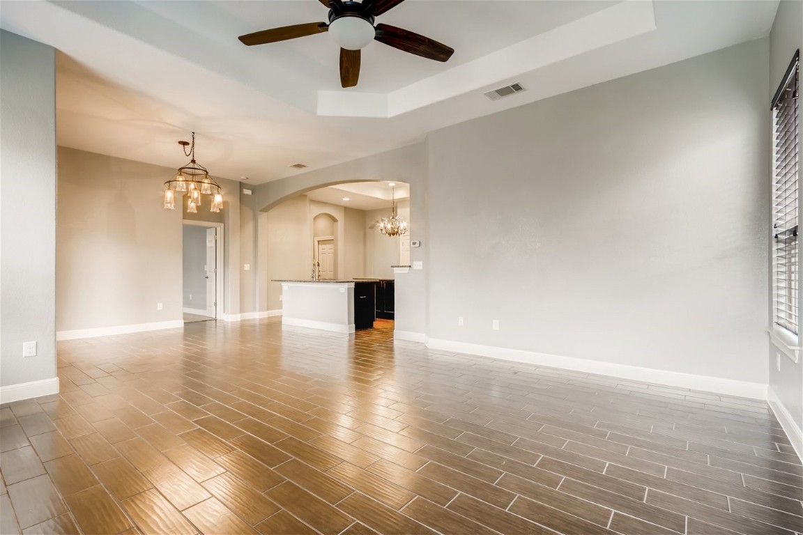 6108 Sabino Drive Spicewood, TX 78669 - Photo 7 of 22 wooden floor in an empty room with a chandelier fan