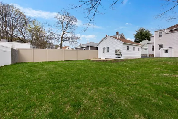 a front view of a house with a yard and trees