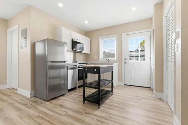a kitchen with stainless steel appliances a refrigerator stove and wooden floor