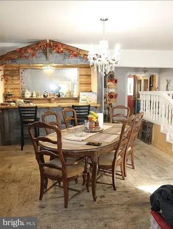 a view of a dining room with furniture a chandelier and wooden floor