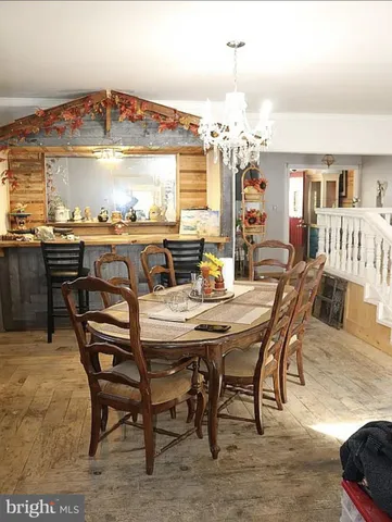 a view of a dining room with furniture a chandelier and wooden floor