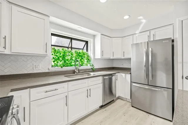 a kitchen with white cabinets and white stainless steel appliances
