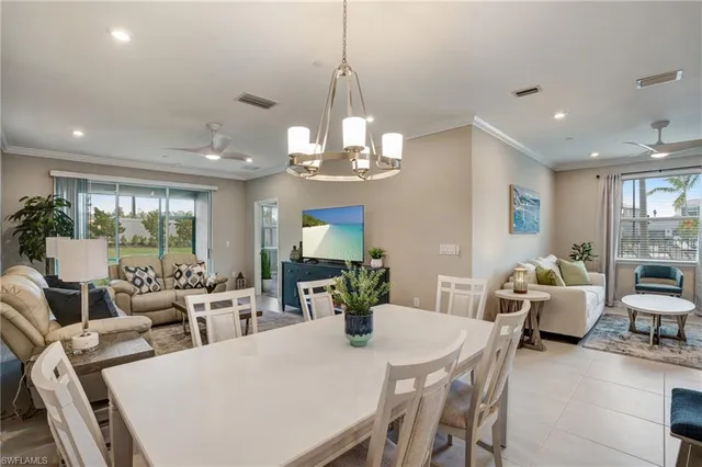 a view of a dining room and livingroom view with furniture wooden floor and chandelier