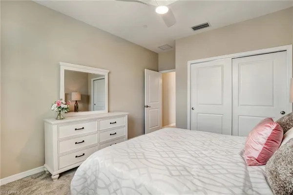 a bedroom with a bed and a mirror on dresser