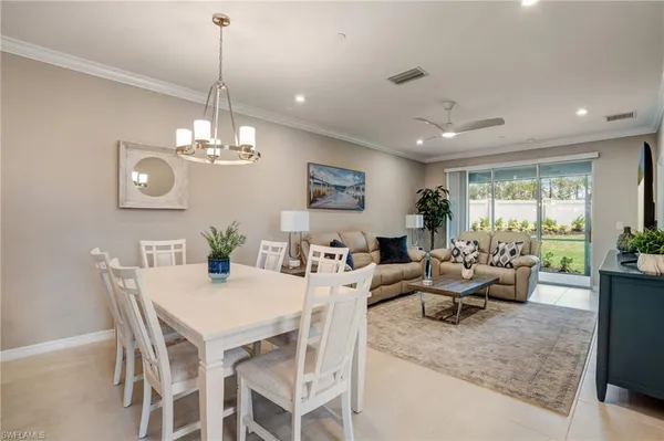 a view of a dining room with furniture a chandelier and wooden floor