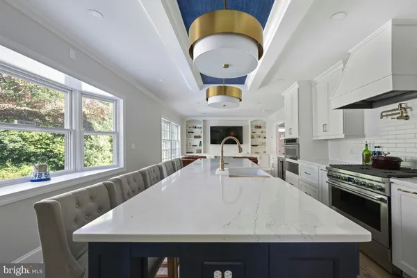 a kitchen with stainless steel appliances a table and chairs