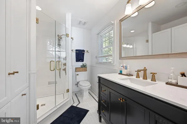 a bathroom with a sink a toilet and shower