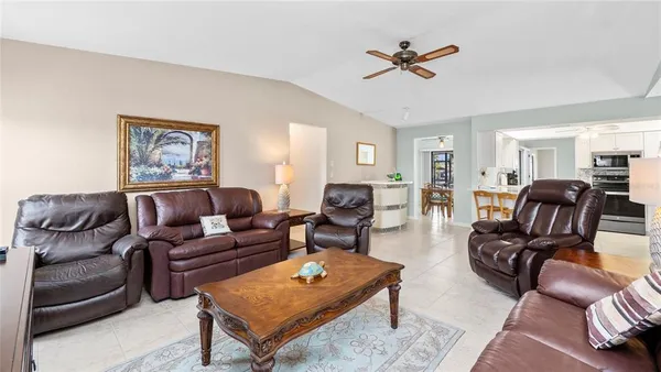 a living room with furniture a ceiling fan and a rug