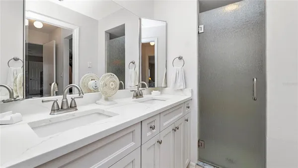 a bathroom with double vanity sink and a mirror