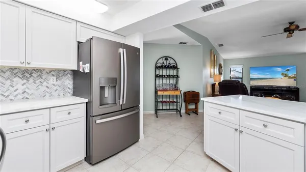 a kitchen with stainless steel appliances white cabinets and a refrigerator