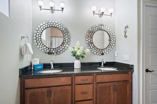 a bathroom with a granite countertop toilet sink and mirror