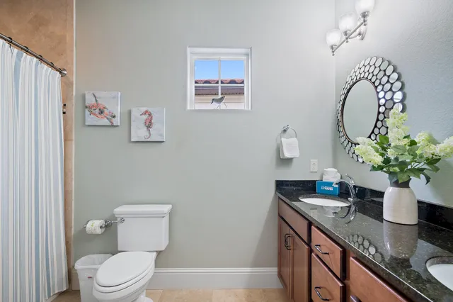 a bathroom with a granite countertop sink a mirror and shower