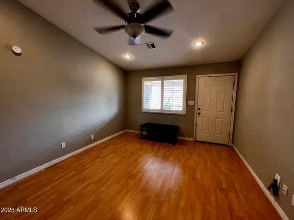 an empty room with wooden floor and windows