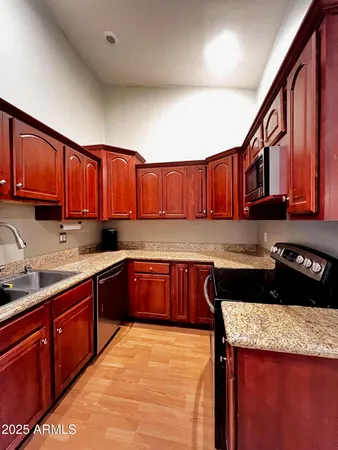 a kitchen with granite countertop a sink and cabinets