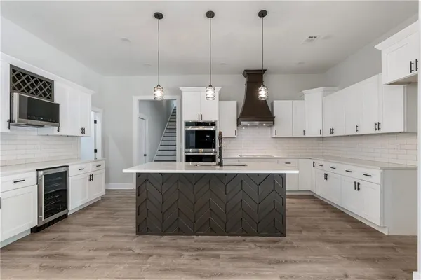 a kitchen with stainless steel appliances granite countertop a stove a sink and a wooden floor