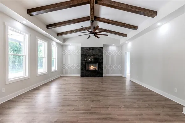 a view of an empty room with a window and fireplace