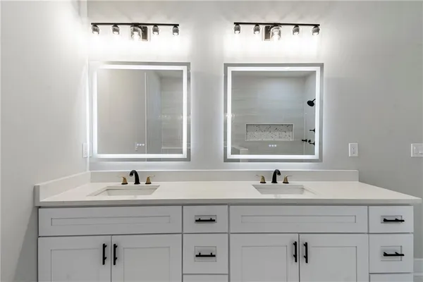 a bathroom with double vanity sink and two mirror
