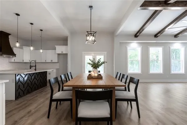a dining room with furniture a chandelier and wooden floor