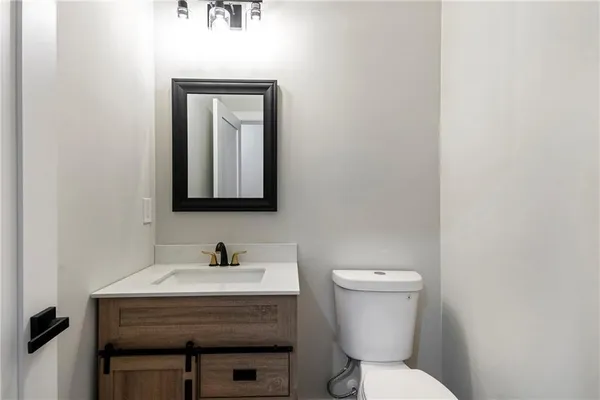 a bathroom with a toilet a sink and mirror