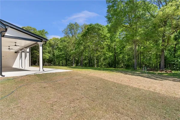 a view of a house with backyard and tree